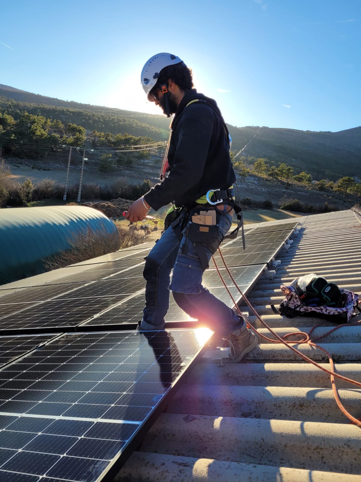 Yoan debout sur un toit entrain d'installer un panneau solaire