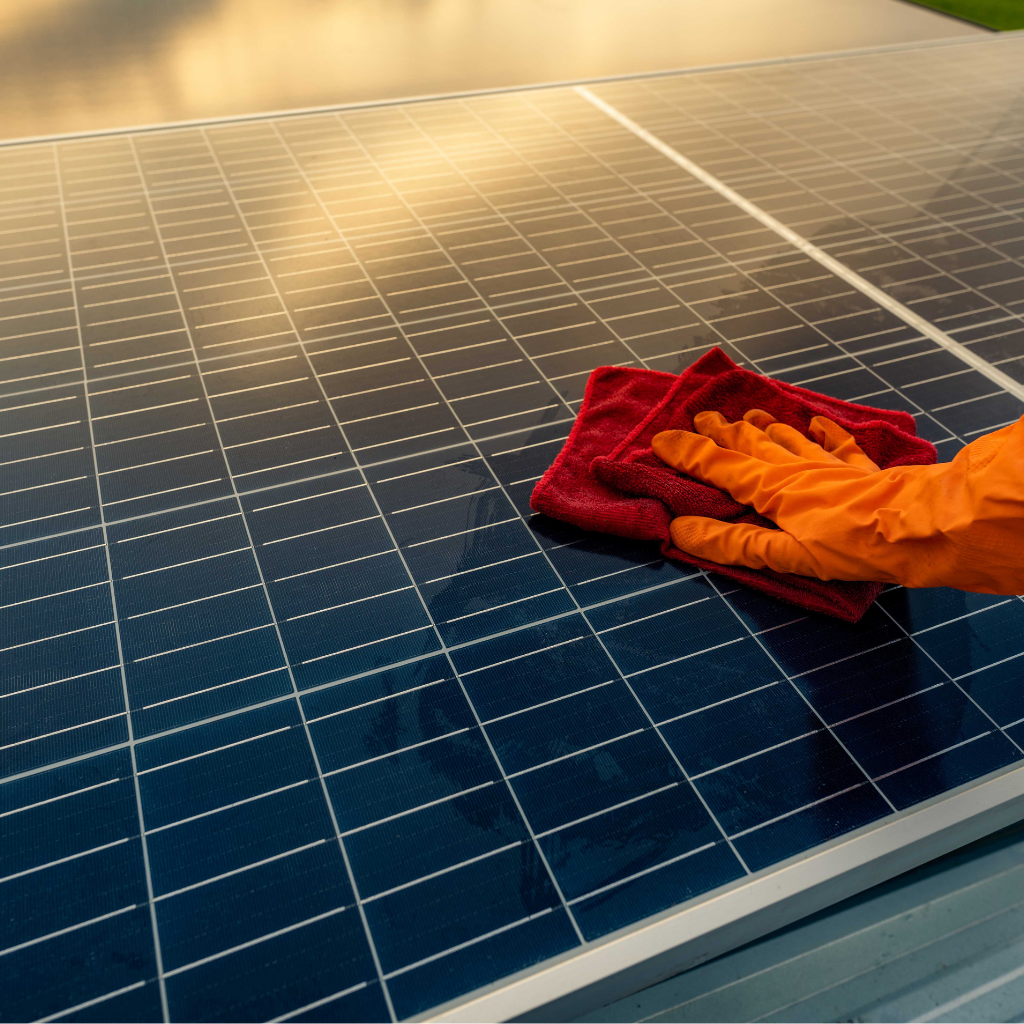 personne qui nettoie un panneau solaire avec un torchon