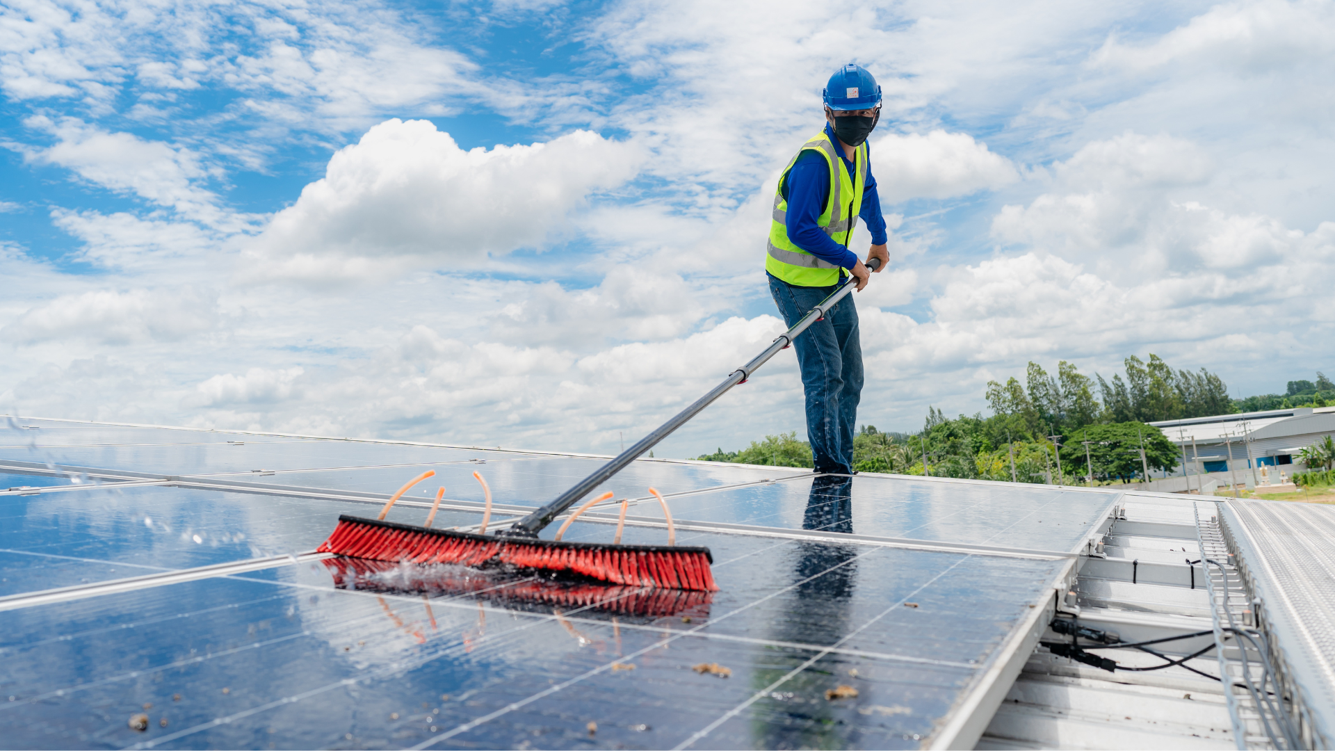 homme nettoyant des panneaux solaires avec un balai brosse